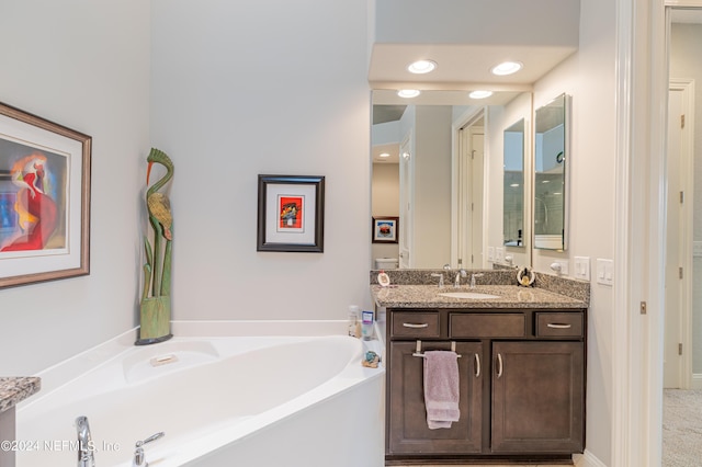 bathroom featuring vanity and a bath