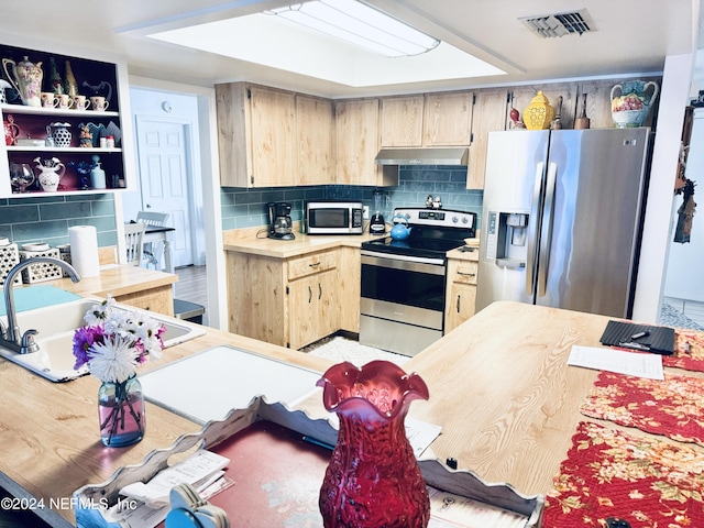 kitchen featuring light brown cabinets, decorative backsplash, light hardwood / wood-style flooring, appliances with stainless steel finishes, and sink