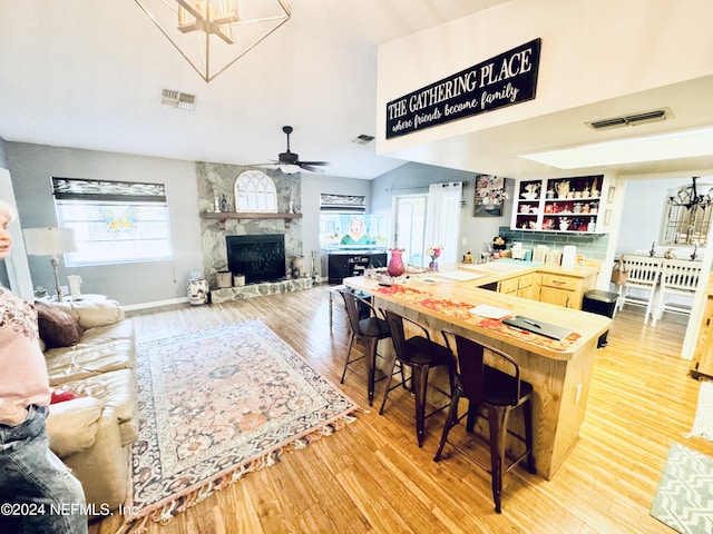 dining room with ceiling fan, light wood-type flooring, and a fireplace