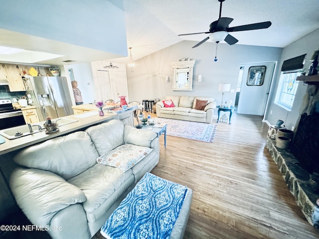 living room with ceiling fan, lofted ceiling, sink, and hardwood / wood-style floors