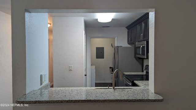 kitchen with light stone countertops, sink, and range with electric cooktop