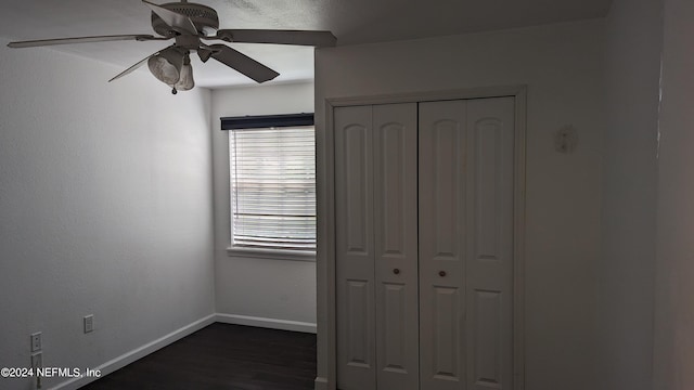 unfurnished bedroom with a closet, ceiling fan, and dark hardwood / wood-style flooring