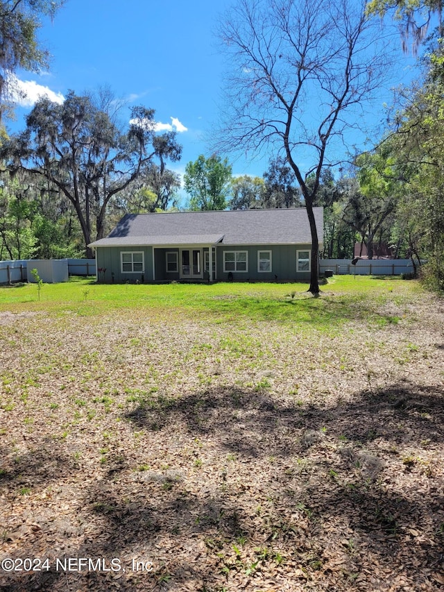 rear view of property with a lawn