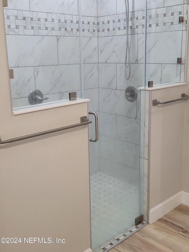 bathroom featuring hardwood / wood-style floors and a shower with door