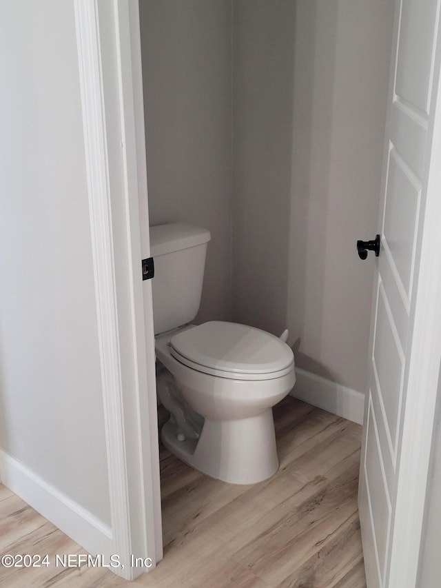 bathroom with hardwood / wood-style floors and toilet