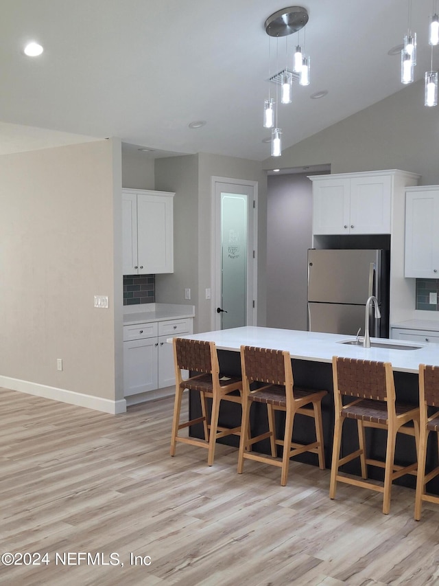 kitchen with decorative light fixtures, tasteful backsplash, stainless steel fridge, and sink