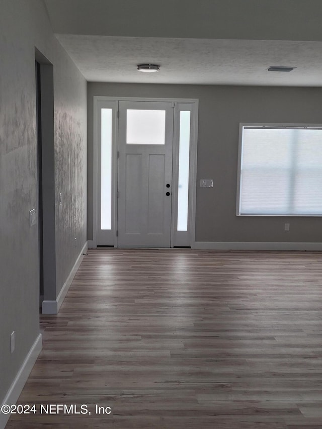 foyer entrance with hardwood / wood-style floors and a textured ceiling