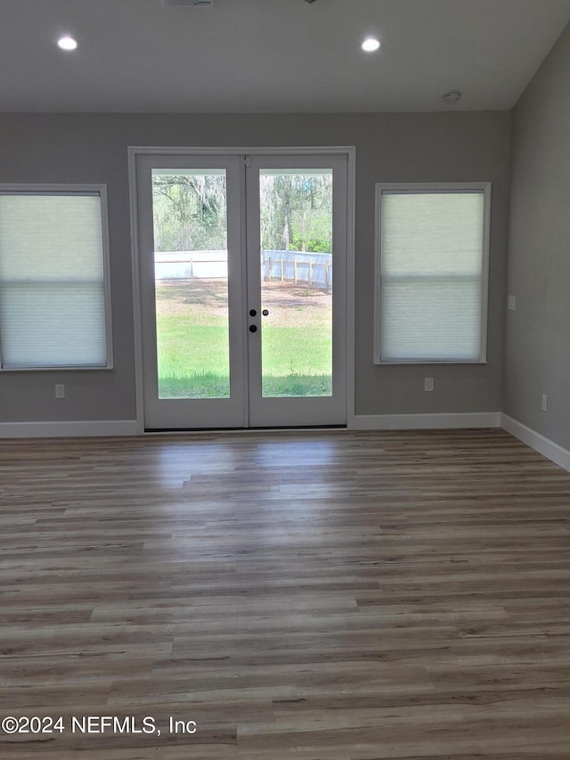 empty room with light hardwood / wood-style floors and french doors