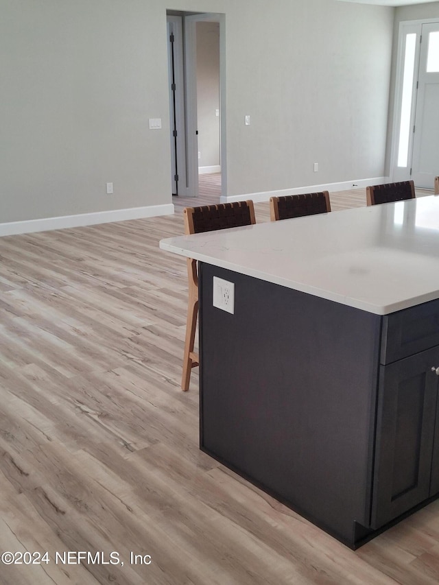 kitchen with a kitchen bar, a kitchen island, and light hardwood / wood-style flooring