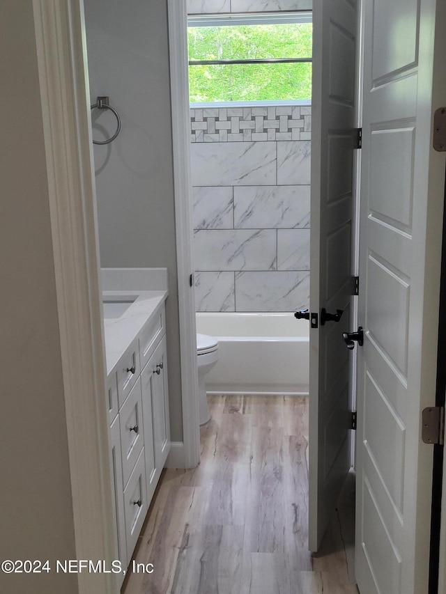 full bathroom with vanity, hardwood / wood-style floors, toilet, and washtub / shower combination