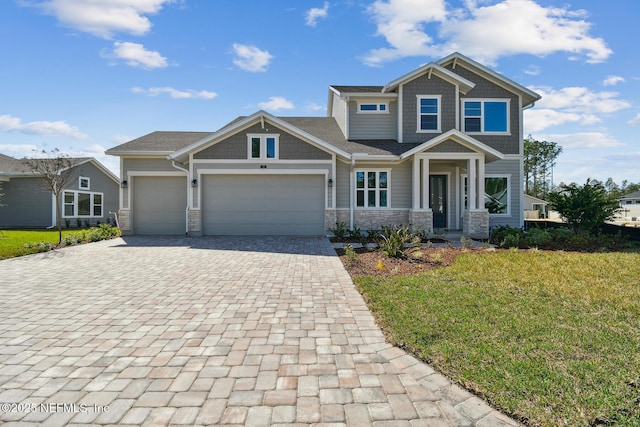 craftsman house with a garage and a front lawn