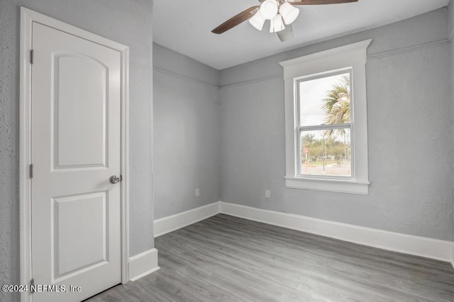 spare room with ceiling fan and light wood-type flooring