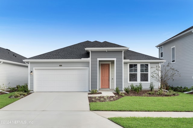 view of front of home featuring a front lawn and a garage