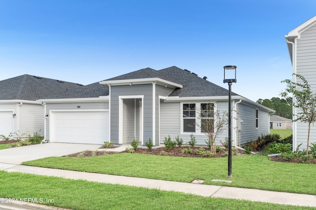 view of front of property with a garage and a front lawn