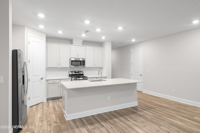 kitchen featuring white cabinets, a center island with sink, appliances with stainless steel finishes, and sink