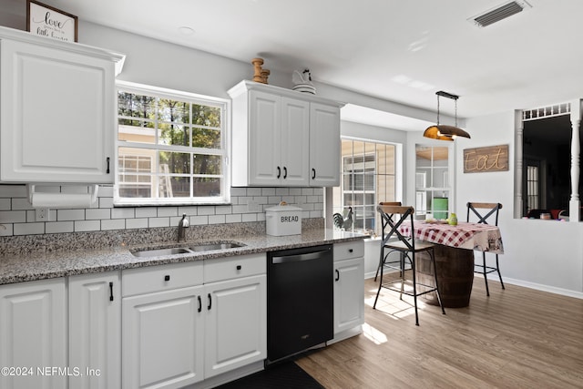 kitchen featuring pendant lighting, white cabinets, dishwashing machine, tasteful backsplash, and light wood-type flooring