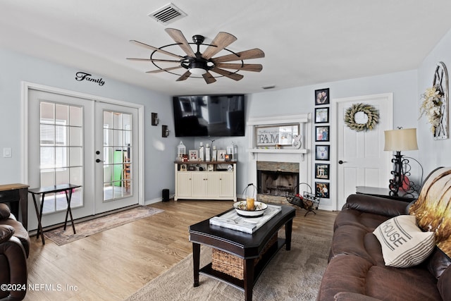 living room featuring french doors, ceiling fan, and light hardwood / wood-style flooring