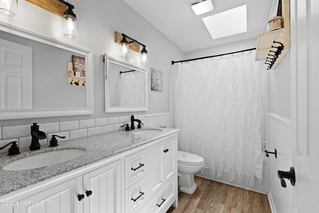 bathroom with wood-type flooring, dual sinks, toilet, tasteful backsplash, and large vanity