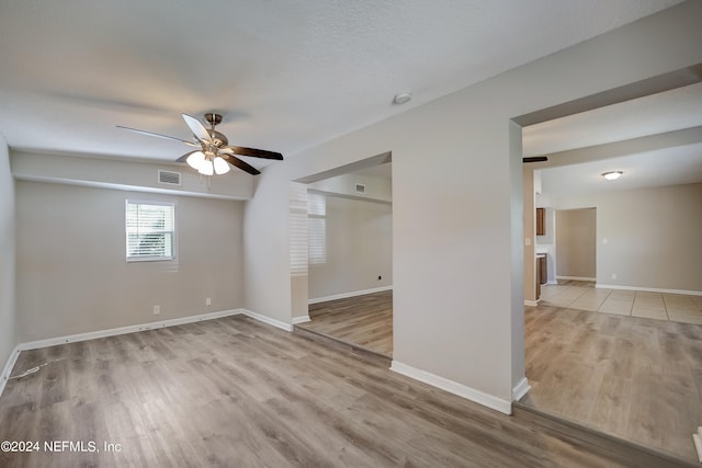 tiled spare room with ceiling fan