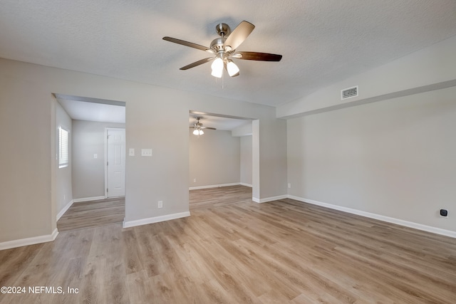 empty room featuring a textured ceiling, ceiling fan, and light hardwood / wood-style flooring