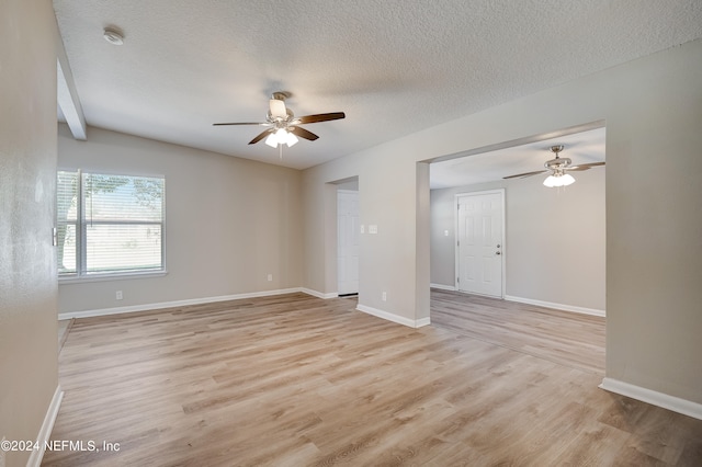 spare room with a textured ceiling, ceiling fan, and light wood-type flooring