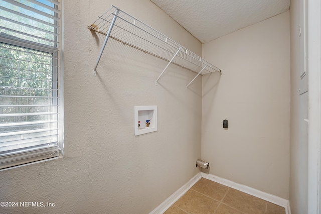 laundry area with washer hookup, tile flooring, a textured ceiling, and a healthy amount of sunlight