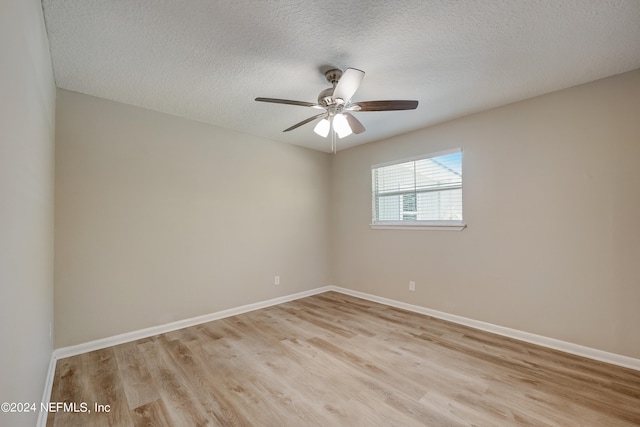 empty room featuring light hardwood / wood-style floors, a textured ceiling, and ceiling fan