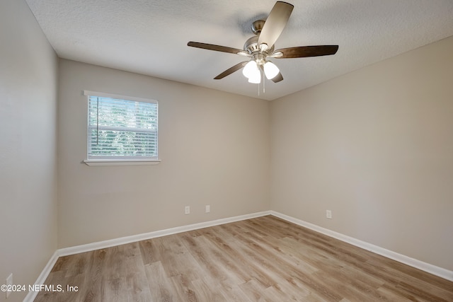 unfurnished room with a textured ceiling, ceiling fan, and light wood-type flooring