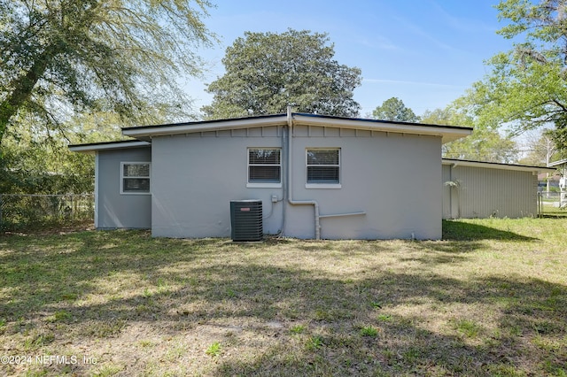 view of side of home featuring a lawn and central AC