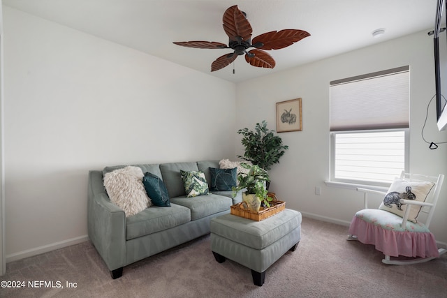 living room with a ceiling fan, baseboards, and carpet flooring