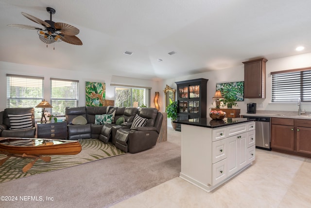 living room with light carpet, a wealth of natural light, vaulted ceiling, and visible vents