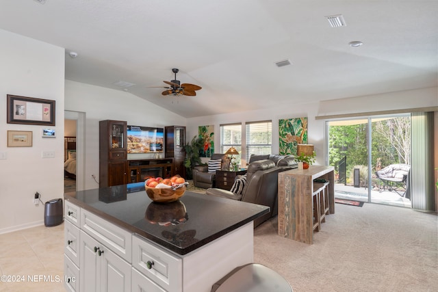 kitchen with visible vents, white cabinets, a ceiling fan, dark countertops, and vaulted ceiling