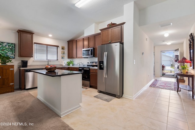 kitchen with visible vents, a center island, vaulted ceiling, stainless steel appliances, and a sink