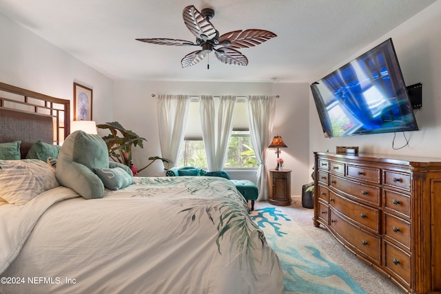 bedroom with a ceiling fan, light carpet, and baseboards