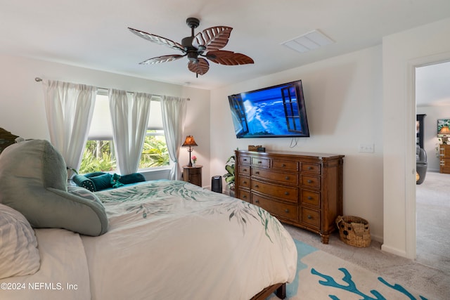 bedroom featuring light colored carpet, ceiling fan, visible vents, and baseboards