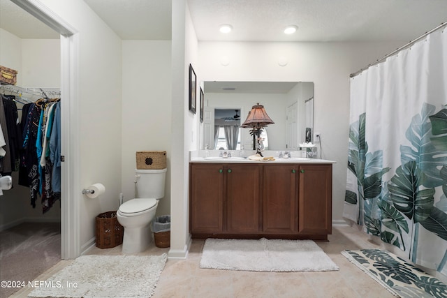 full bathroom with double vanity, curtained shower, toilet, and a sink