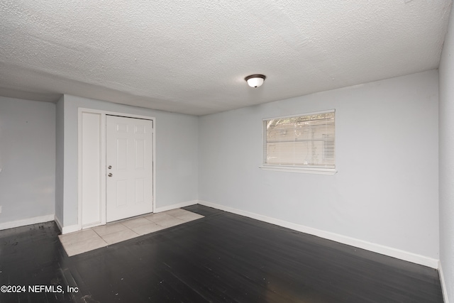 interior space with a textured ceiling and dark wood-type flooring