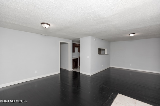 unfurnished room with dark hardwood / wood-style floors and a textured ceiling