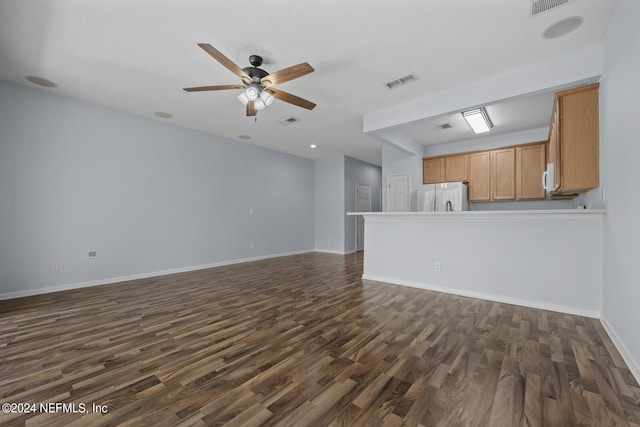 unfurnished living room featuring ceiling fan and dark wood-type flooring