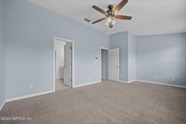 unfurnished bedroom featuring ceiling fan, ensuite bathroom, and light carpet