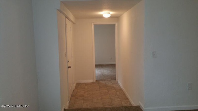 corridor with dark tile floors