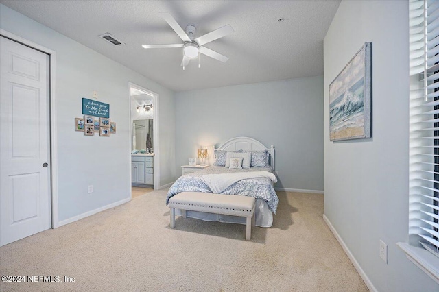 carpeted bedroom with connected bathroom, ceiling fan, and a textured ceiling