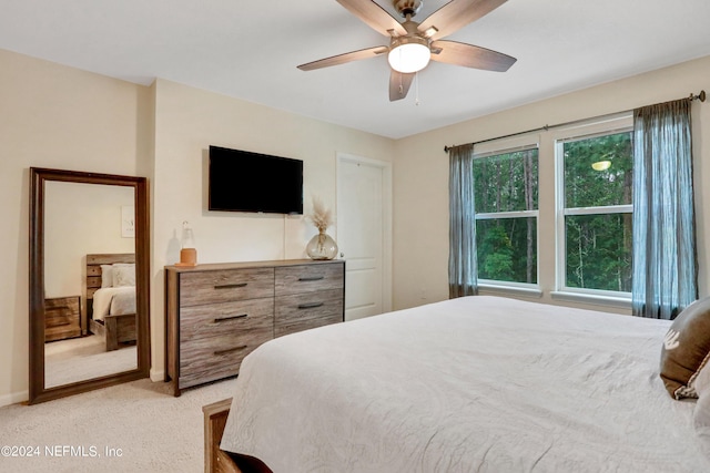 bedroom with ceiling fan and light colored carpet