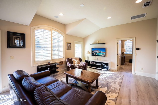 living room featuring vaulted ceiling and light hardwood / wood-style floors