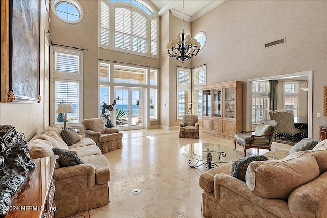 living room featuring french doors, ornamental molding, an inviting chandelier, and a high ceiling