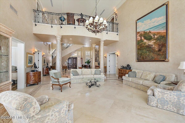 living room featuring a chandelier, decorative columns, and a high ceiling