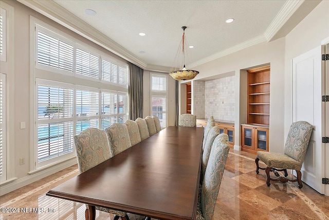 dining area featuring a textured ceiling, crown molding, and built in features