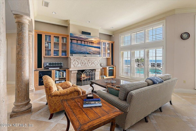 living room featuring decorative columns, ornamental molding, and beverage cooler