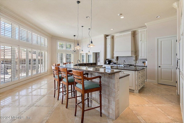 kitchen featuring kitchen peninsula, decorative light fixtures, a breakfast bar, crown molding, and decorative backsplash