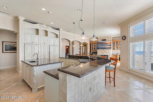 kitchen featuring hanging light fixtures, a breakfast bar area, a large island, and sink